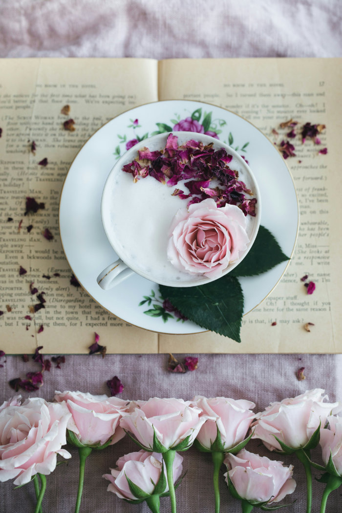 A beautiful table setting and bouquets of roses that symbolize the enjoyment of a good romance story.